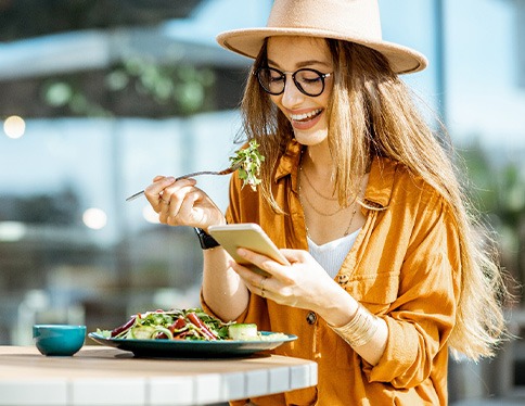 Woman smiling while eating lunch outside
