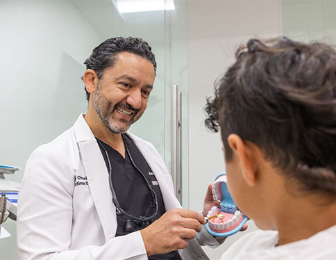 Smiling dentist shaking hands with dental patient