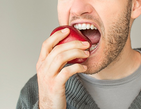 A man biting into an apple