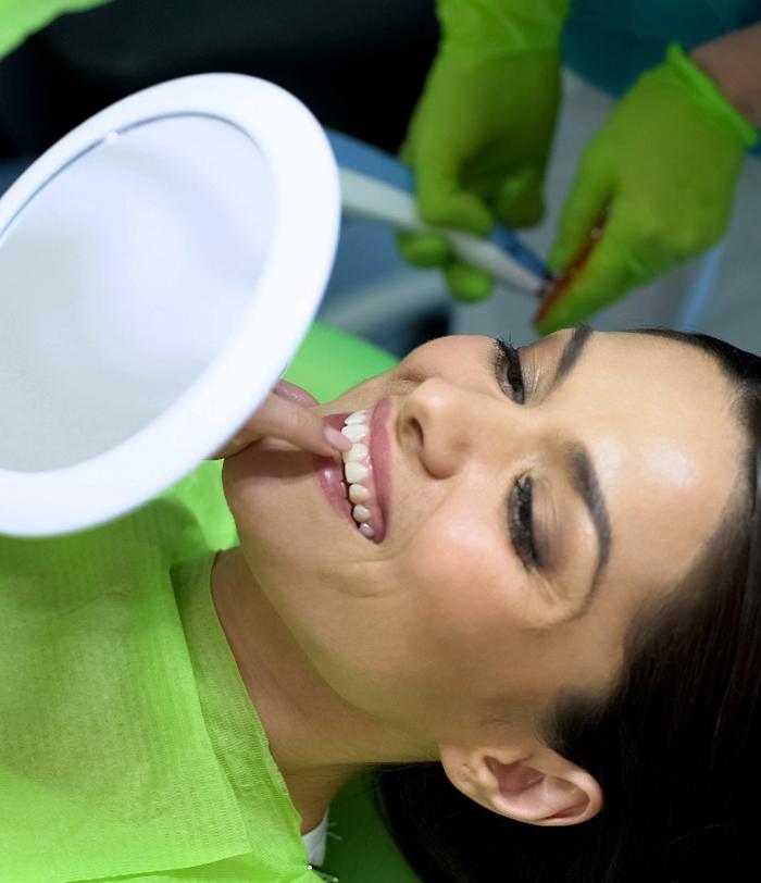 Woman looking at her new smile with dental bonding in San Juan Capistrano