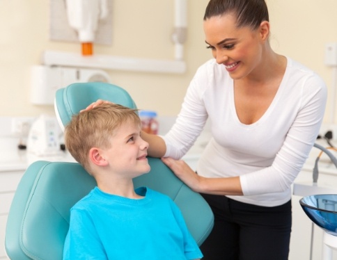 Child smiling at dental team member during dental checkup and teeth cleaning visit