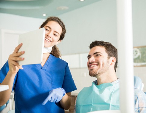 Dentist showing patient image on tablet