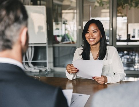 Woman smiling while holding resume in job interview