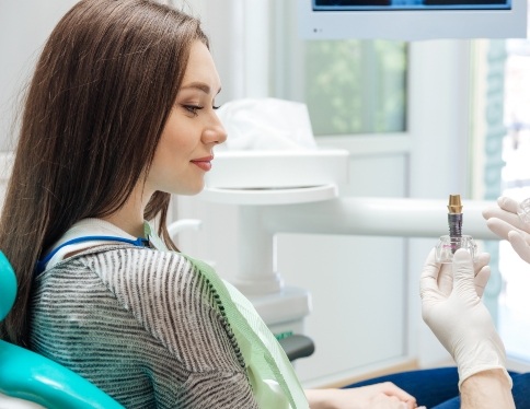 Woman discussing keys to preventing dental emergencies with dentist