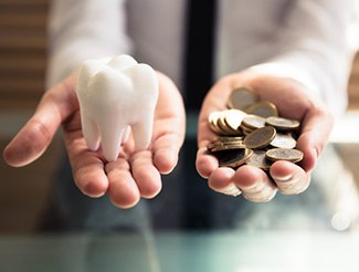 Hands holding coins and tooth representing price of dental implants in San Juan Capistrano