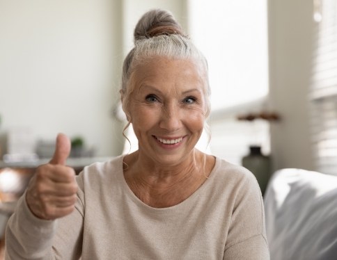 Woman smiling and giving thumbs up