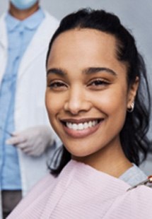 Mujer sonriendo mientras está sentada en la silla de tratamiento del dentista