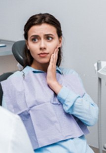 Mujer con dolor de muelas preocupada mientras habla con el dentista
