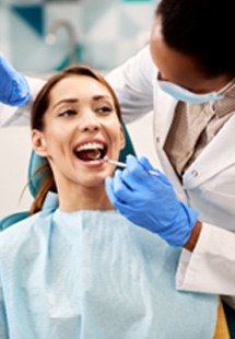 Mujer sonriendo mientras el dentista examina sus encías