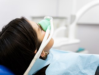 Woman relaxing in treatment chair while breathing in nitrous oxide