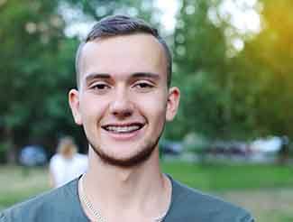 Young man with braces smiling