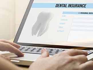 Filling out dental insurance form on laptop
