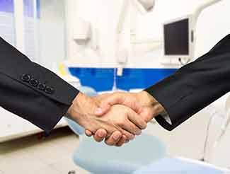 Close-up of dentist and patient shaking hands