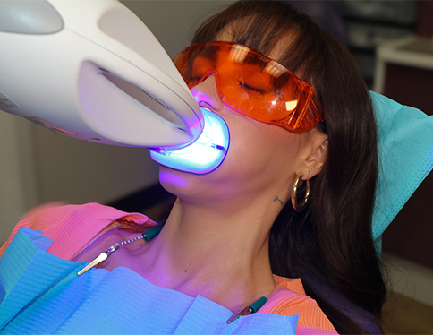 Woman delicately touching her whitened teeth