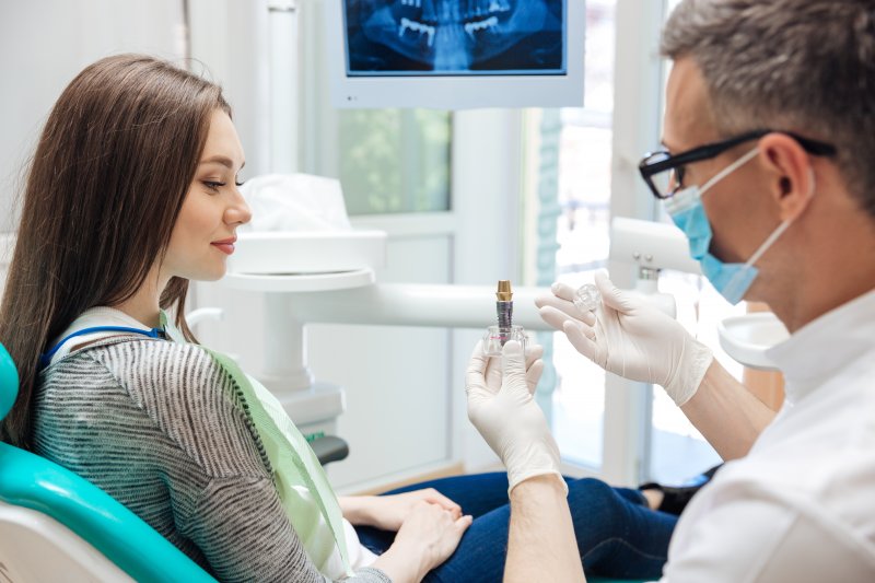 A dentist explaining to his patient how dental implants work