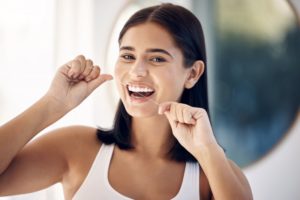 a woman flossing her teeth