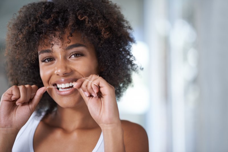 Patient flossing with old-school floss